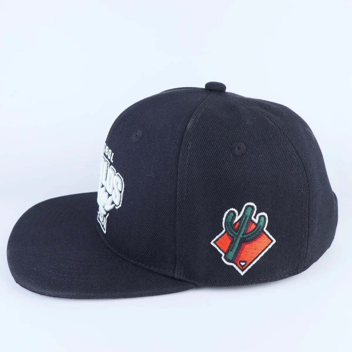 Side of a dark navy cap showing a colored side emblem and white front lettering