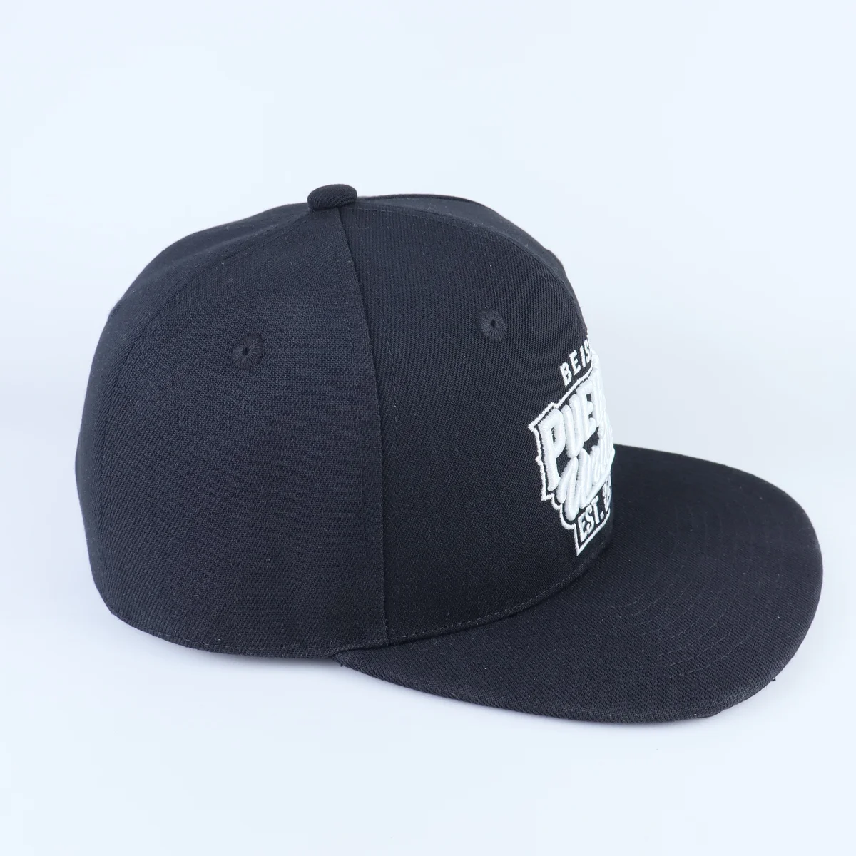 Three-quarter view of a dark navy embroidered cap with a flat-looking visor