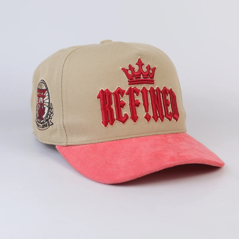 Three-quarter angle of khaki and coral cap showing side crest embroidery