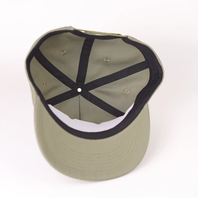 Inside of a khaki compact-brim cap showing dark seam tape and sweatband