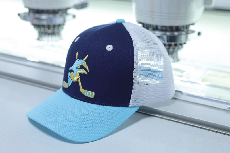Navy-front trucker cap with aqua visor, white mesh and multicolor front embroidery