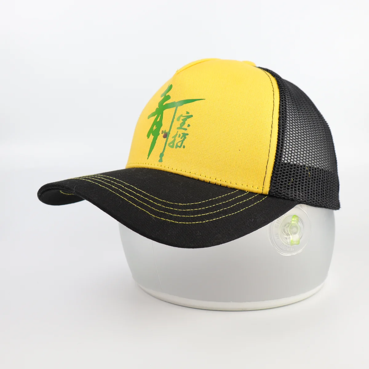 Side view of a yellow-front trucker cap showing black mesh and yellow visor stitching